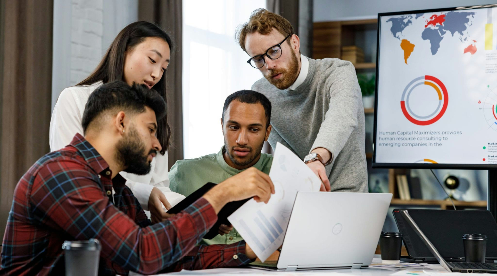 Team discussing a project around a laptop